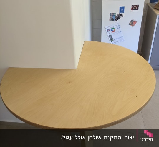 שולחן עץ עגול מחובר לקיר עם רגל תומכת